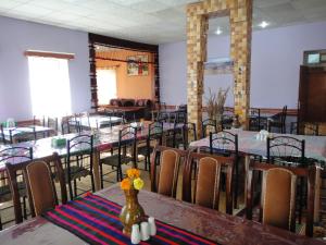 uma sala de jantar com mesas e cadeiras com flores na mesa em Noorband Qalla Hotel,Bamyan 