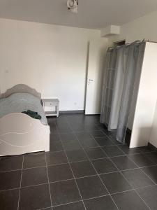 a bedroom with a bed and a tiled floor at Un studio dans la résidence SJT in Alençon