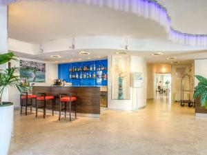 um bar num hotel com bancos vermelhos em Mercure Rimini Lungomare em Rimini