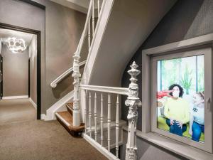 a home hallway with a staircase with a movie on the wall at ibis Styles Amsterdam Amstel in Amsterdam