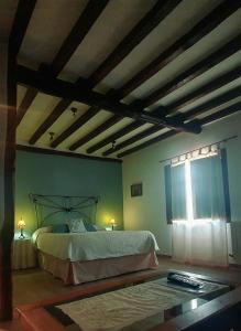 sypialnia z dużym łóżkiem i oknem w obiekcie El Jardín del Laurel w mieście Candelario