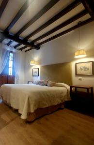 a bedroom with a large bed and two lights at El Jardín del Laurel in Candelario