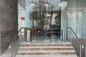 una entrada de cristal a un edificio con escaleras en ماجيك سويت الفحيحيل Magic Suite ALFahaheel en Kuwait
