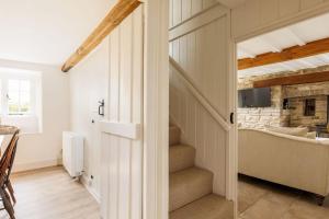 einen Flur mit einer Treppe, die zu einem Wohnzimmer führt in der Unterkunft Honeysuckle Cottage in Wareham
