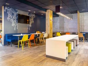 a dining room with colorful chairs and tables at ibis budget Ludwigsburg -RENOVIERT IN 2024!- in Ludwigsburg