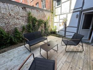 3 Stühle und ein Tisch auf einer Terrasse in der Unterkunft Gîte "Au Fourneau" in Spa