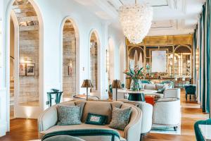 a lobby with chairs and tables and a chandelier at Hilton Imperial Dubrovnik in Dubrovnik