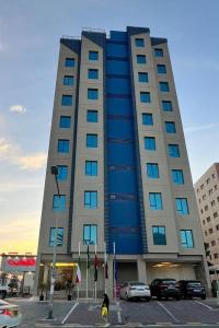 een hoog gebouw met auto's geparkeerd voor het bij ماجيك سويت الفحيحيل Magic Suite ALFahaheel in Koeweit