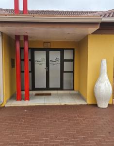 a building with a vase sitting in front of it at Divine Guest Lodge in Rustenburg