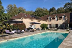a house with a swimming pool with chairs and umbrellas at Appartement Chic, Climatisation et Piscine in Ormoy-la-Rivière