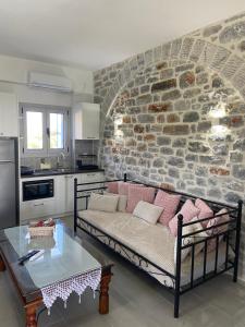 a living room with a couch and a stone wall at Yulie's Orama in Areopoli