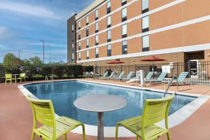 a patio with chairs and a table and a pool at Newly Renovated - Home2 Suites by Hilton Knoxville West in Knoxville
