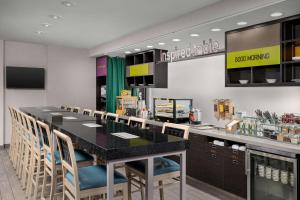 Newly Renovated - Home2 Suites by Hilton Knoxville West في نوكسفيل: مطعم مع كونتر أسود كبير مع كراسي