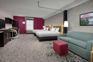 a hotel room with two beds and a couch at Newly Renovated - Home2 Suites by Hilton Knoxville West in Knoxville