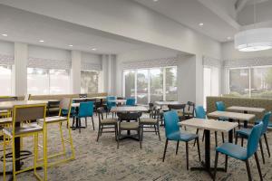 jadalnia ze stołami, krzesłami i oknami w obiekcie Hilton Garden Inn Raleigh Capital Blvd I-540 w mieście Raleigh