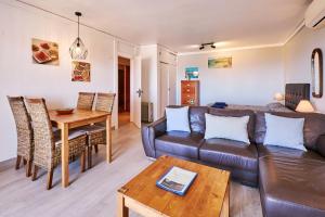 een woonkamer met een bank en een tafel bij Apartment Carina mit wunderschönen Meerlblick in Armação de Pêra