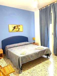 1 dormitorio con 1 cama con pared azul en Case La Spiaggia, en Sciacca