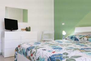 - une chambre avec un lit et une télévision dans l'établissement La casa verde, à Cinisi