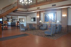 a lobby with chairs and tables and a staircase at Quality Inn in Perrysburg