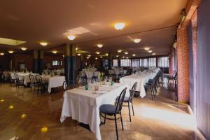 un salón de banquetes con mesas y sillas blancas en HOTEL BRUNFORTE, en Sarnano