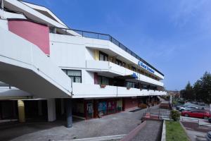 a large white building with a parking lot at HOTEL BRUNFORTE in Sarnano