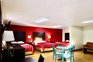a hotel room with two beds and a table and chairs at Rodeway Inn in Pauls Valley