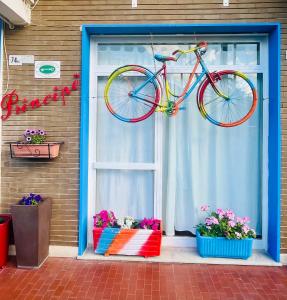 a bike is hanging on a window with flowers at Hotel Principe in Pietra Ligure