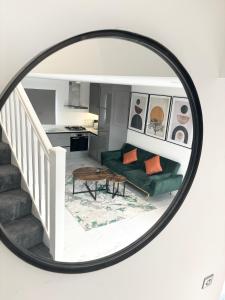 um espelho que reflecte uma sala de estar com um sofá verde em Bvlgaria house - Private gated parking em Slough