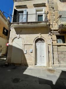 um edifício com uma porta branca e uma varanda em Casa Caracciolo em Lecce