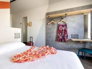 1 dormitorio con 1 cama y un vestido colgado en la pared en ibis Budget La Rochelle Centre en La Rochelle