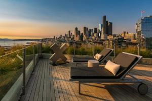 two chairs and a table on a deck with a city skyline at Pioneer Sq 1BR w WD Gym BBQ Sound view SEA-157 in Seattle