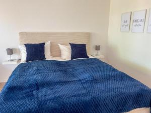 Schlafzimmer mit blauer Decke auf einem Bett in der Unterkunft Ankerherz Appartements bei Blankenese in Hamburg