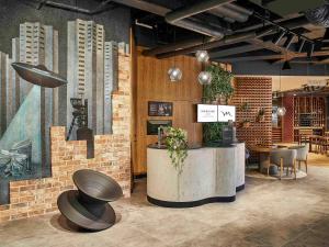 a restaurant with a table and chairs and a mural at Mercure Katowice Centrum in Katowice