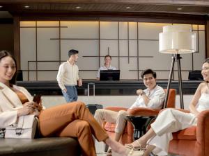 a group of people sitting around in a room at Grand Mercure Bangkok Atrium in Bangkok