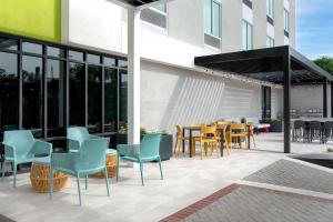 a patio with chairs and tables on a building at Home2 Suites By Hilton Jacksonville Downtown in Jacksonville