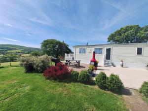 ein Haus mit einem Picknicktisch davor in der Unterkunft Countryside Caravan Accommodation - Abergele in Abergele