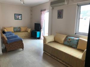 a living room with two couches and a tv at Loutraki Vacation in Loutraki