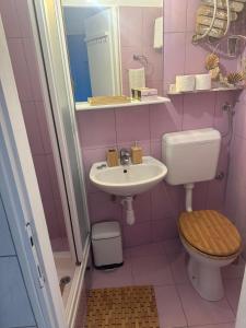 uma casa de banho rosa com um WC e um lavatório em Old Town Lucky Star Apartments Split em Split