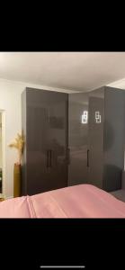a bedroom with gray cabinets and a bed with pink sheets at Villa Volga in Jelsa