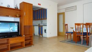 a living room with a television and a dining room at Quinta Gomeira by Amandio Batista in Cabanas de Tavira