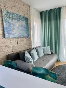 a living room with a couch and a brick wall at Bubbles Penthouse with Jacuzzi in Podstrana