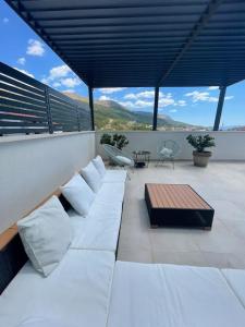 a white couch on a balcony with a table at Bubbles Penthouse with Jacuzzi in Podstrana