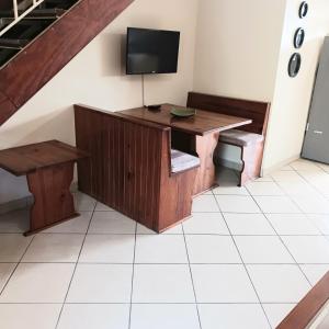 Habitación con escritorio y TV en una escalera. en Flamingo Holiday Flats, en St Lucia