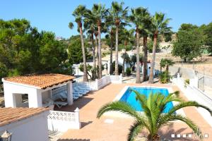 una villa con piscina e palme di VH CostaBlanca-Oasis a Benissa