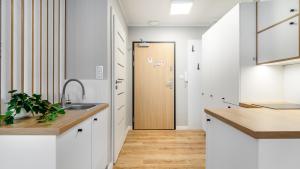 a kitchen with a sink and a door to a hallway at STEGNA PARK B Apartamenty PIAMOLA in Stegna +146 photos