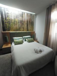 ein Schlafzimmer mit einem großen weißen Bett mit grünen Kissen in der Unterkunft CASA DE PERAIS in Perais