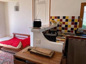 ein Zimmer mit einer Küche und einem kleinen Zimmer mit einem Tisch in der Unterkunft Charmante maison de village in Porto-Vecchio