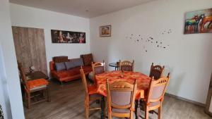 a dining room with a table and chairs and a couch at FeWo Nitteler Zauberpfoten in Nittel +2 photos