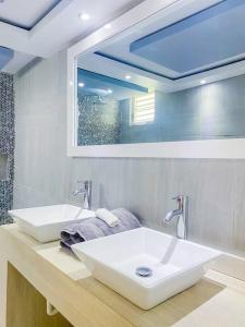 ein Badezimmer mit zwei Waschbecken und einem großen Spiegel in der Unterkunft Blue Paradise - - Fajardo, PR in Fajardo