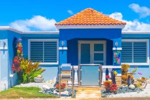 ein blaues Haus mit einem Stuhl davor in der Unterkunft Blue Paradise - - Fajardo, PR in Fajardo